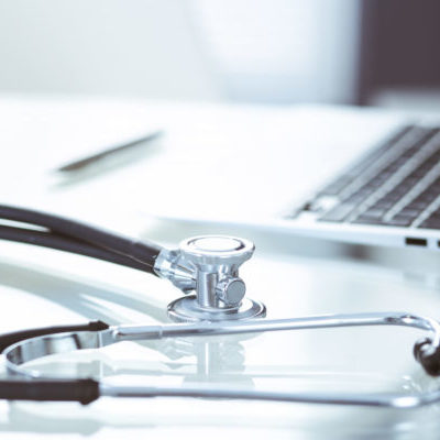 stethoscope, prescription medical form lying on glass table with laptop computer. medicine or pharmacy concept. medical tools at doctor working table